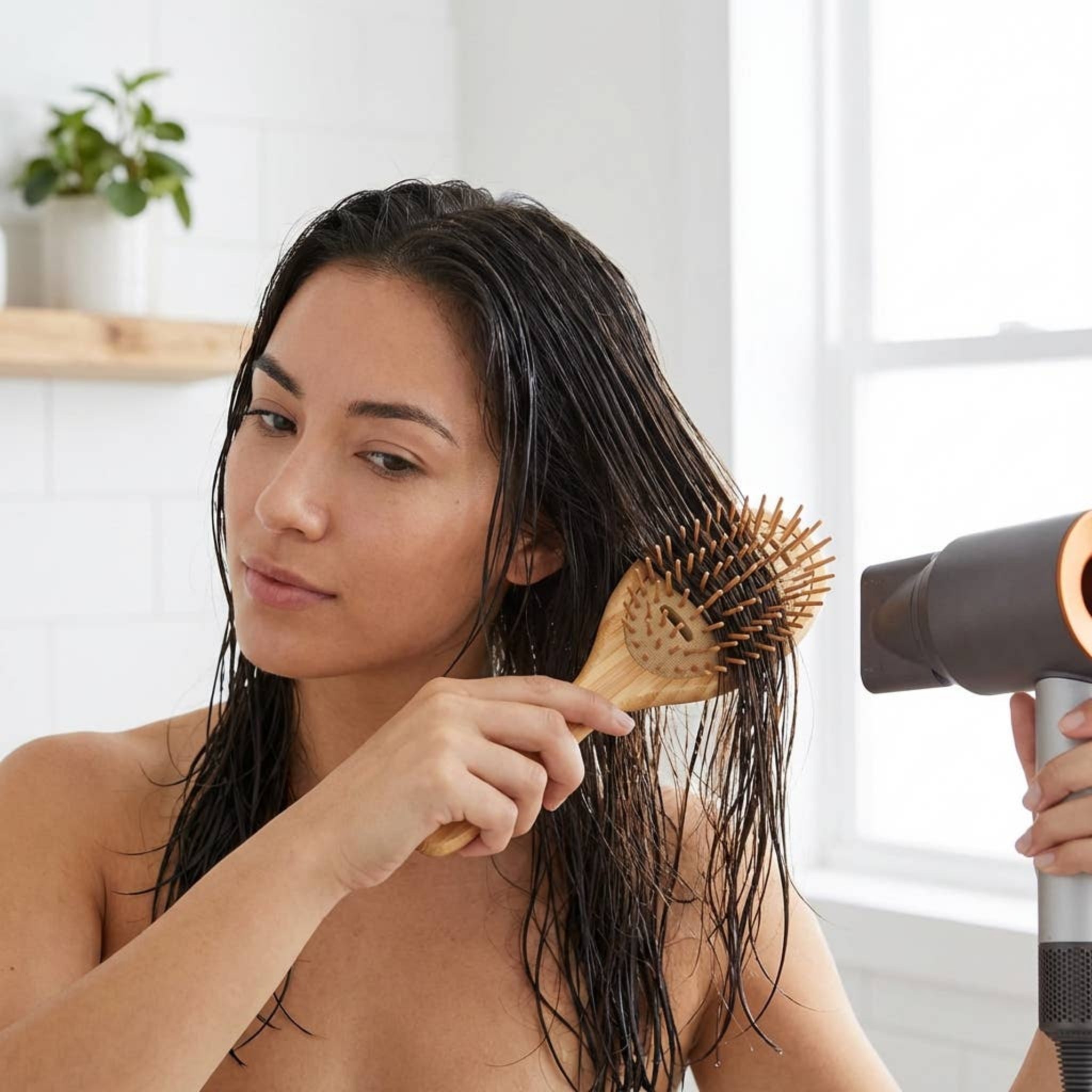 Bamboo vented wet hair brush held to wet hair, oval paddle with pin bristles