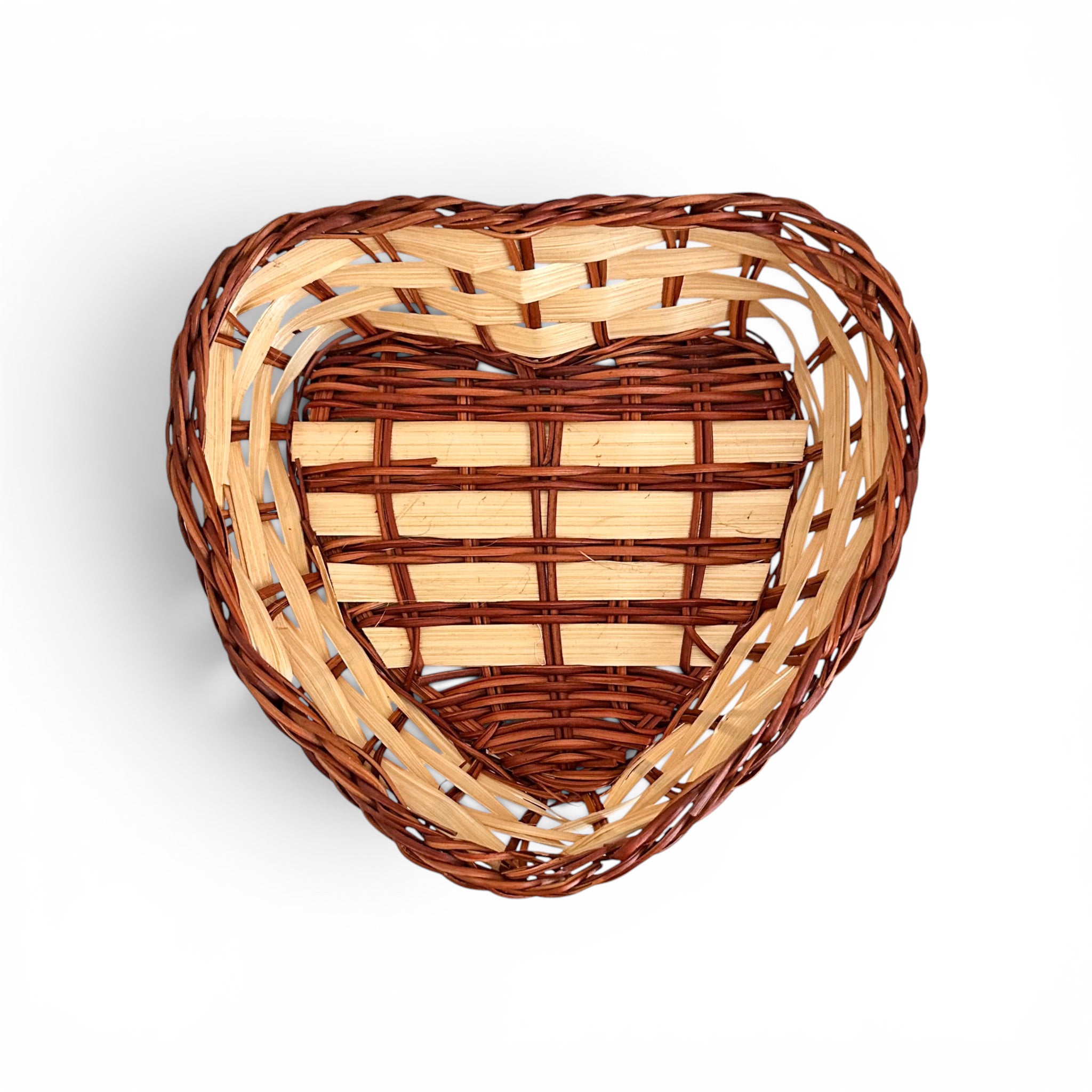 A heart-shaped woven basket made from dark brown and light natural wood, shown from a top-down perspective on a white background.