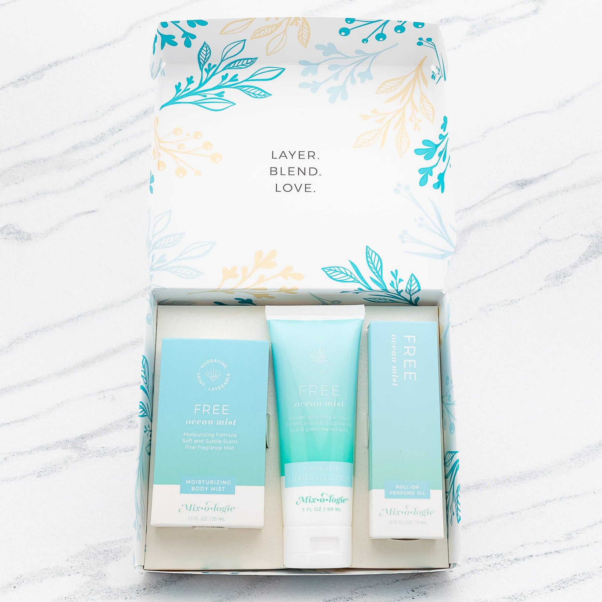 Three skincare products in a box with decorative packaging on a marble surface