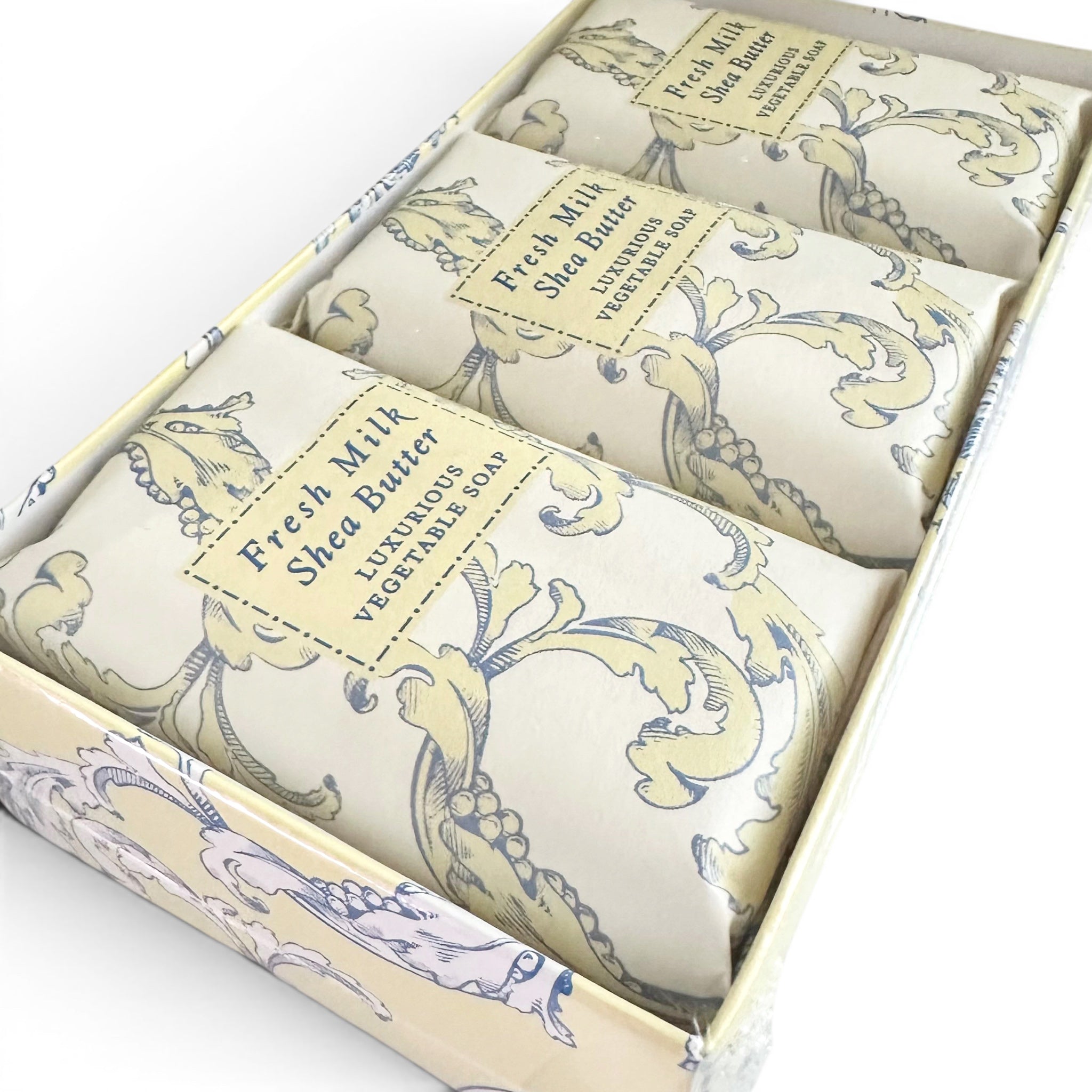 Set of three soap bars in decorative packaging with visible branding.