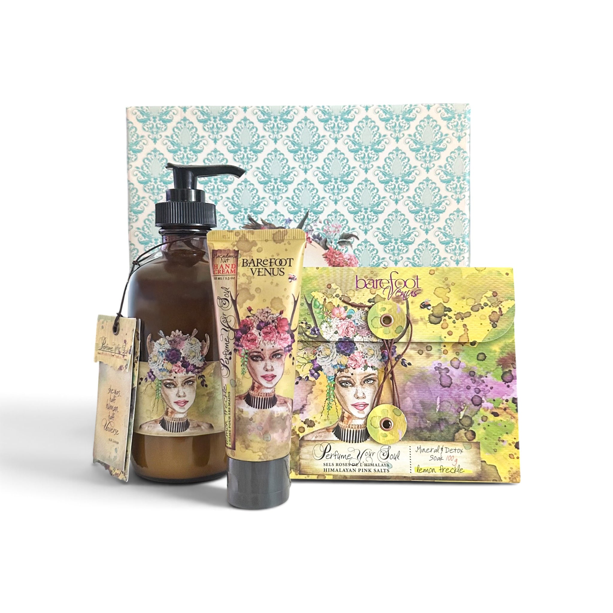 A Barefoot Venus self-care gift set featuring an amber glass bottle with a black pump, a hand cream tube, a colorful envelope-style soap dish, and a patterned gift box, all decorated with a vintage-style portrait illustration.