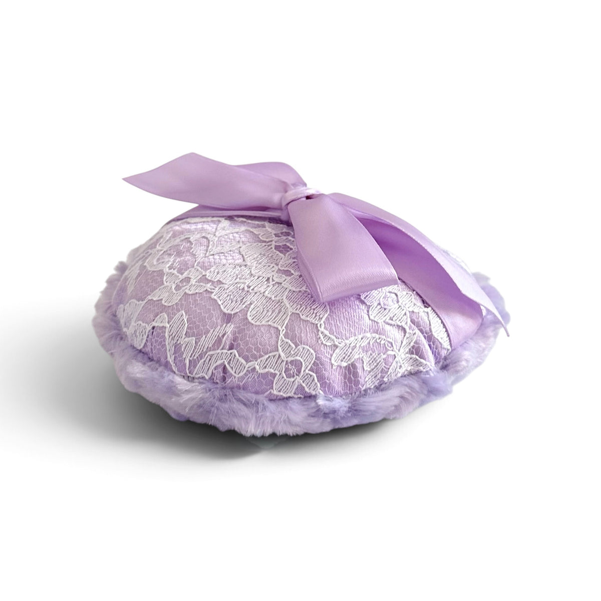 A lavender purple lace and faux fur pillow with a matching satin ribbon bow, photographed on a clean white background.