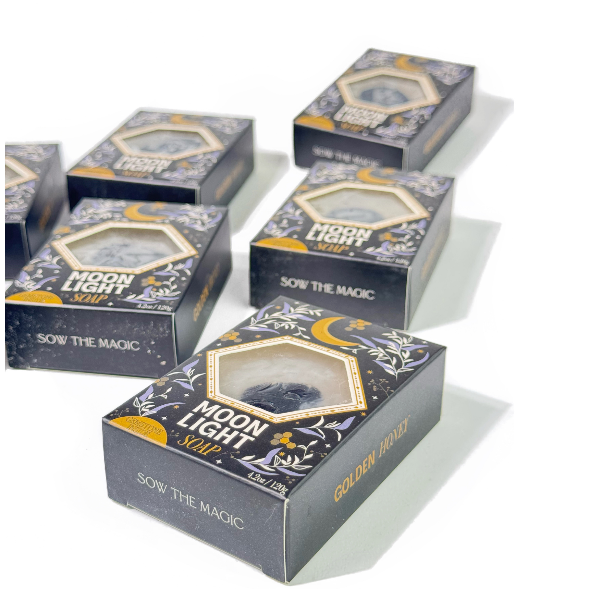 Multiple boxes of 'Moon Light' soap with decorative designs on a white background