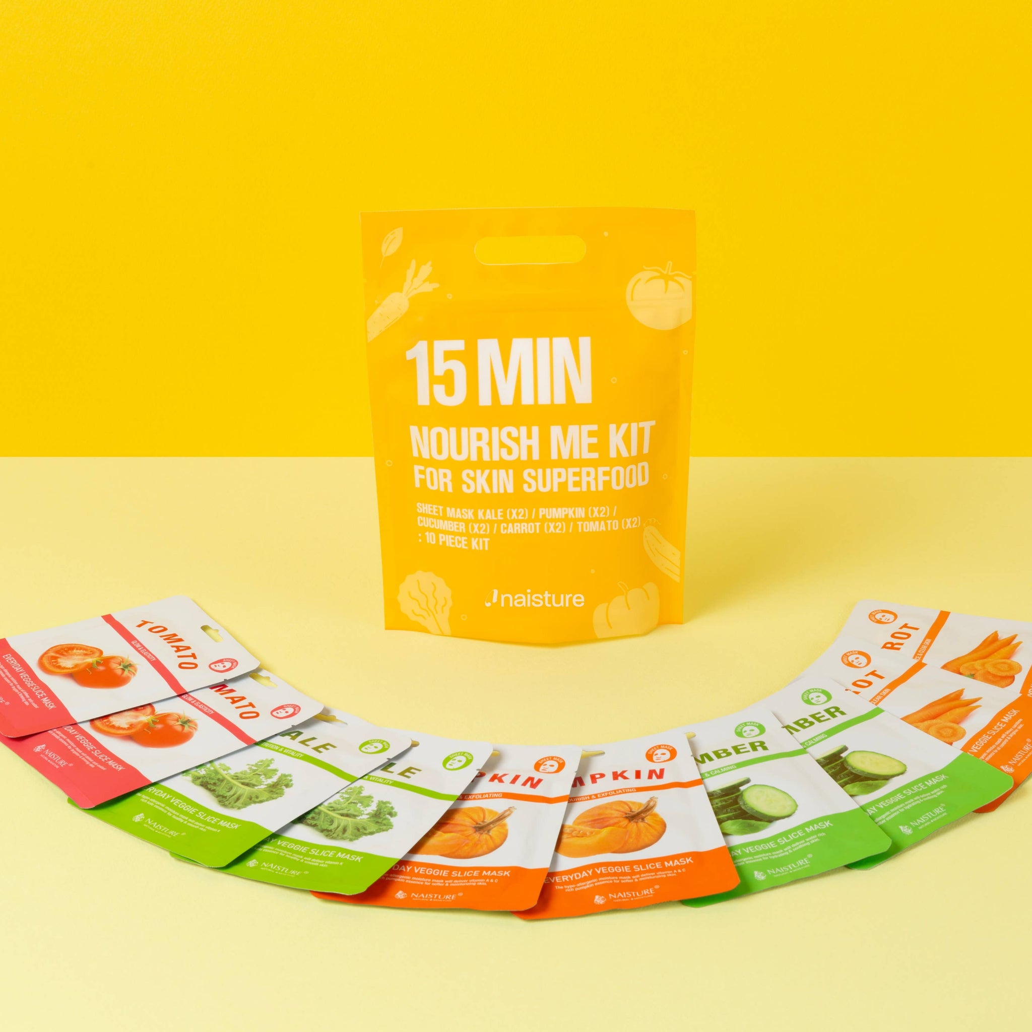 Colorful veggie sheet mask pouches fanned with a standing 15 MIN kit pouch