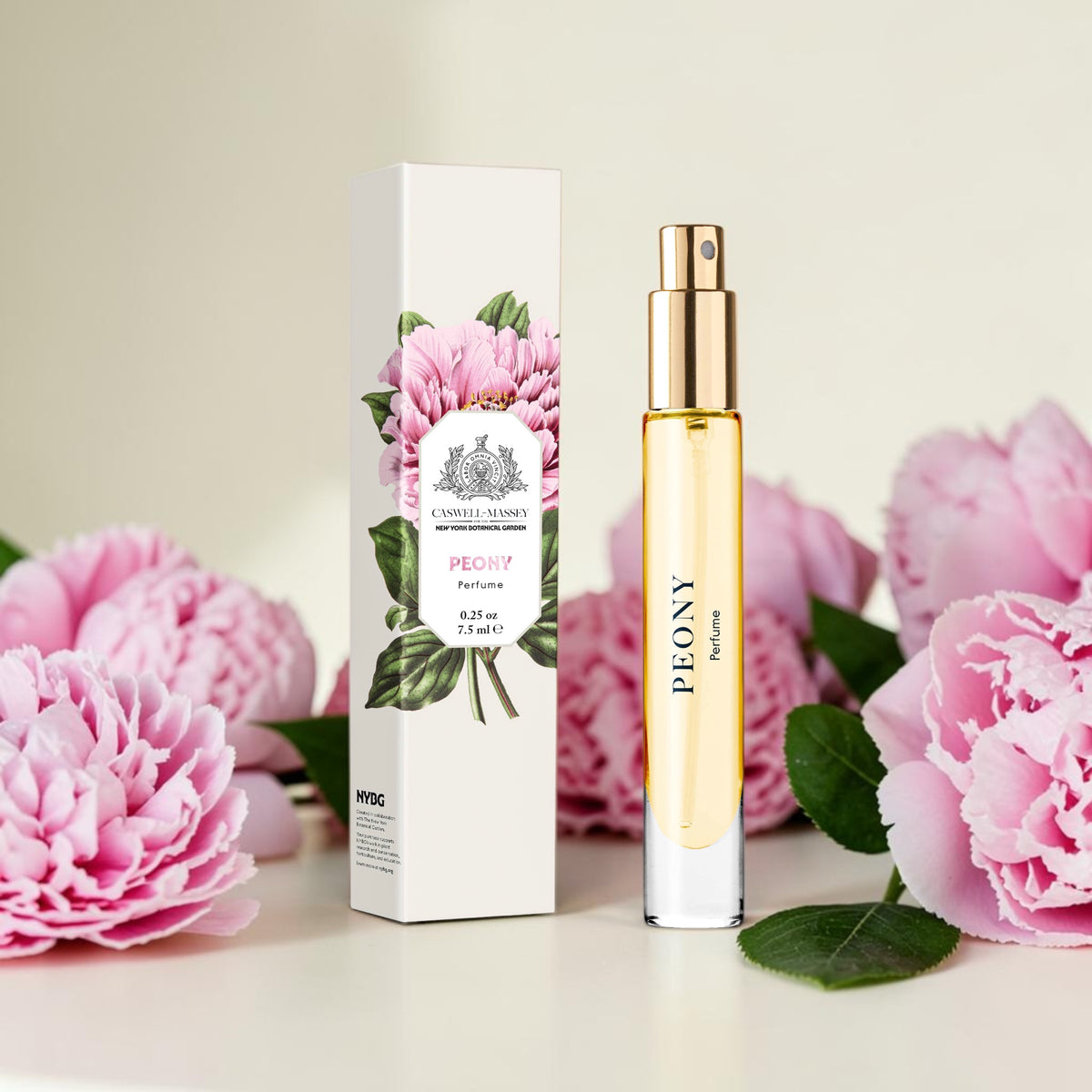 A perfume bottle and its matching box from Caswell Massey, labeled 'PEONY' and 'Saffron', styled with pink peony flowers on a light beige background.