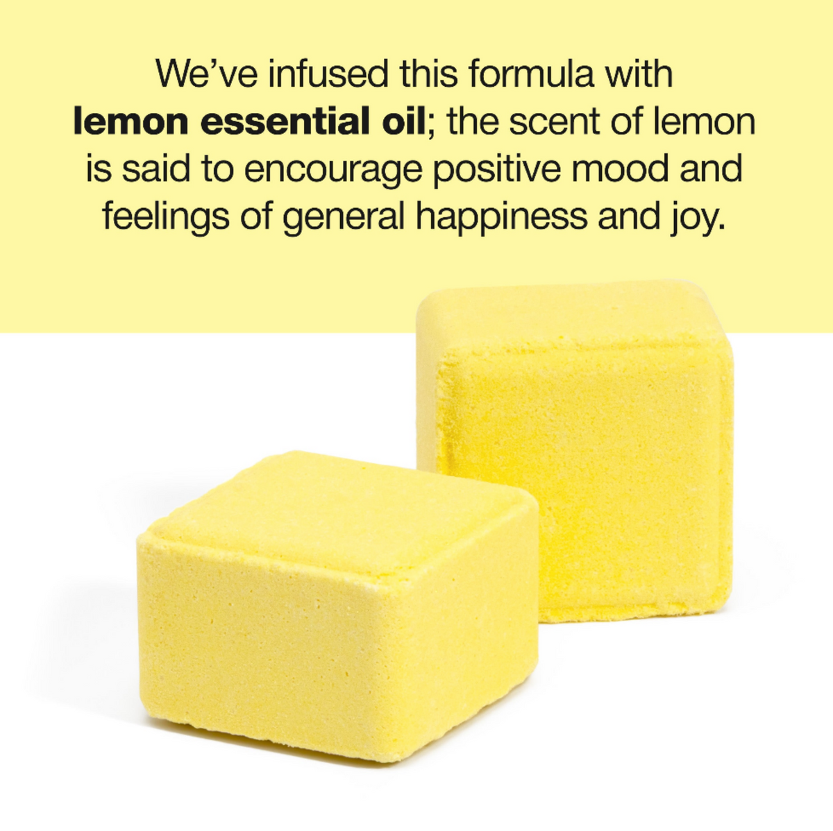 Two yellow cube-shaped bath salts on a white background with a pale yellow text banner at the top explaining the lemon essential oil infusion.