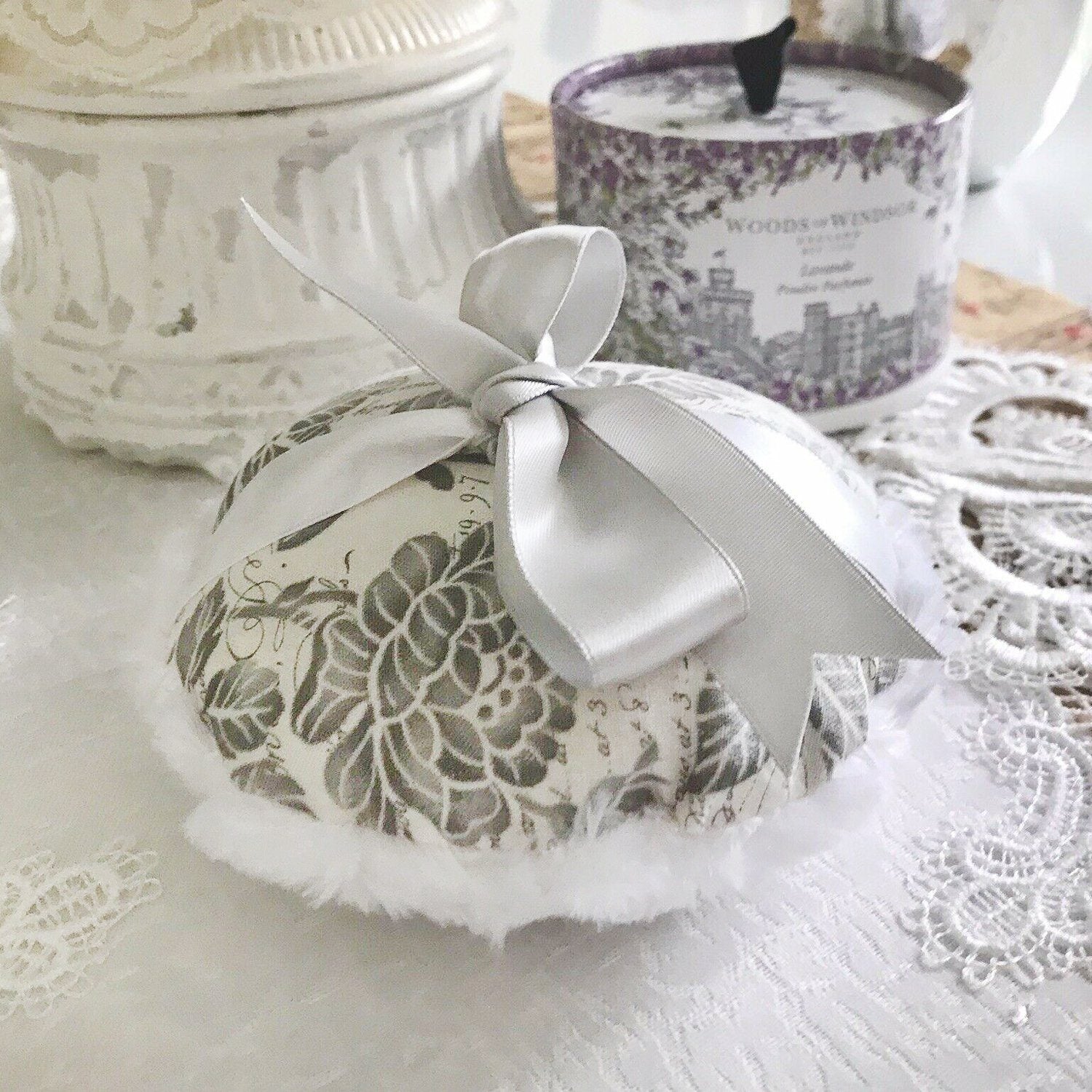 Large gray-and-white floral powder puff with satin bow and fluffy white trim