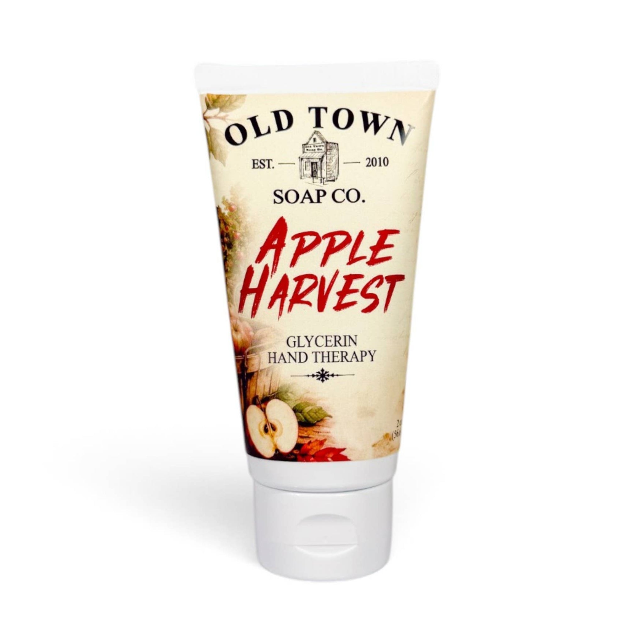A squeeze tube of Old Town Soap Co. 'Apple Harvest' glycerin hand therapy, featuring a cream-colored label with red text and apple illustrations, on a white background.