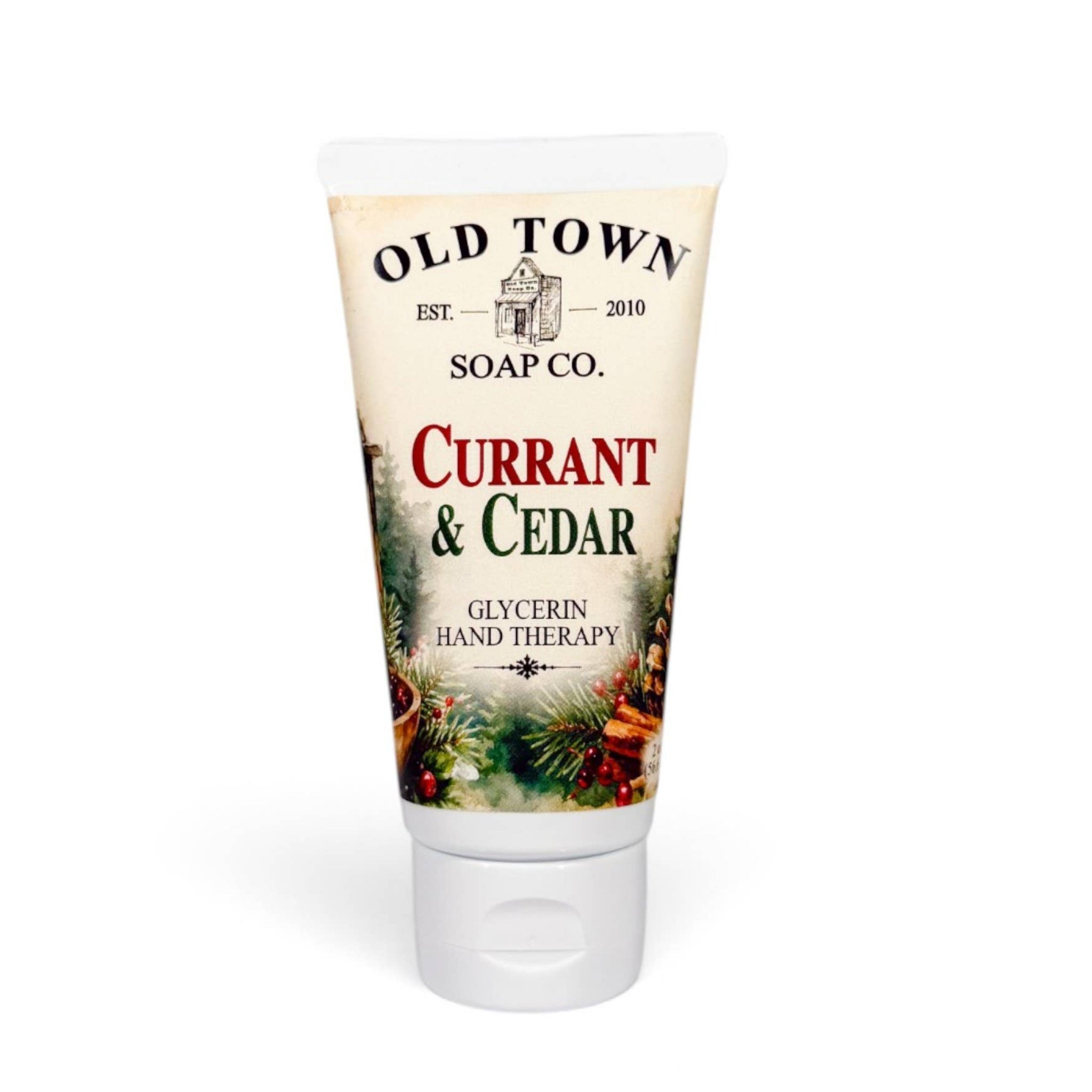 A squeeze tube of Old Town Soap Co. 'Currant & Cedar' glycerin hand therapy soap, featuring a cream-colored label with red and green text and pine illustrations, set against a plain white background.