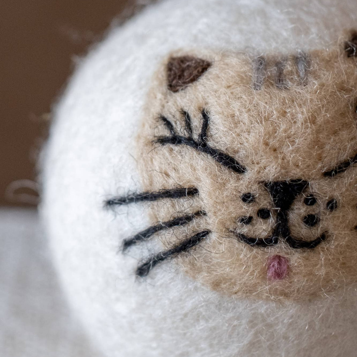 Natural wool dryer balls gift set of 3, close-up of a cat-face ball with whiskers
