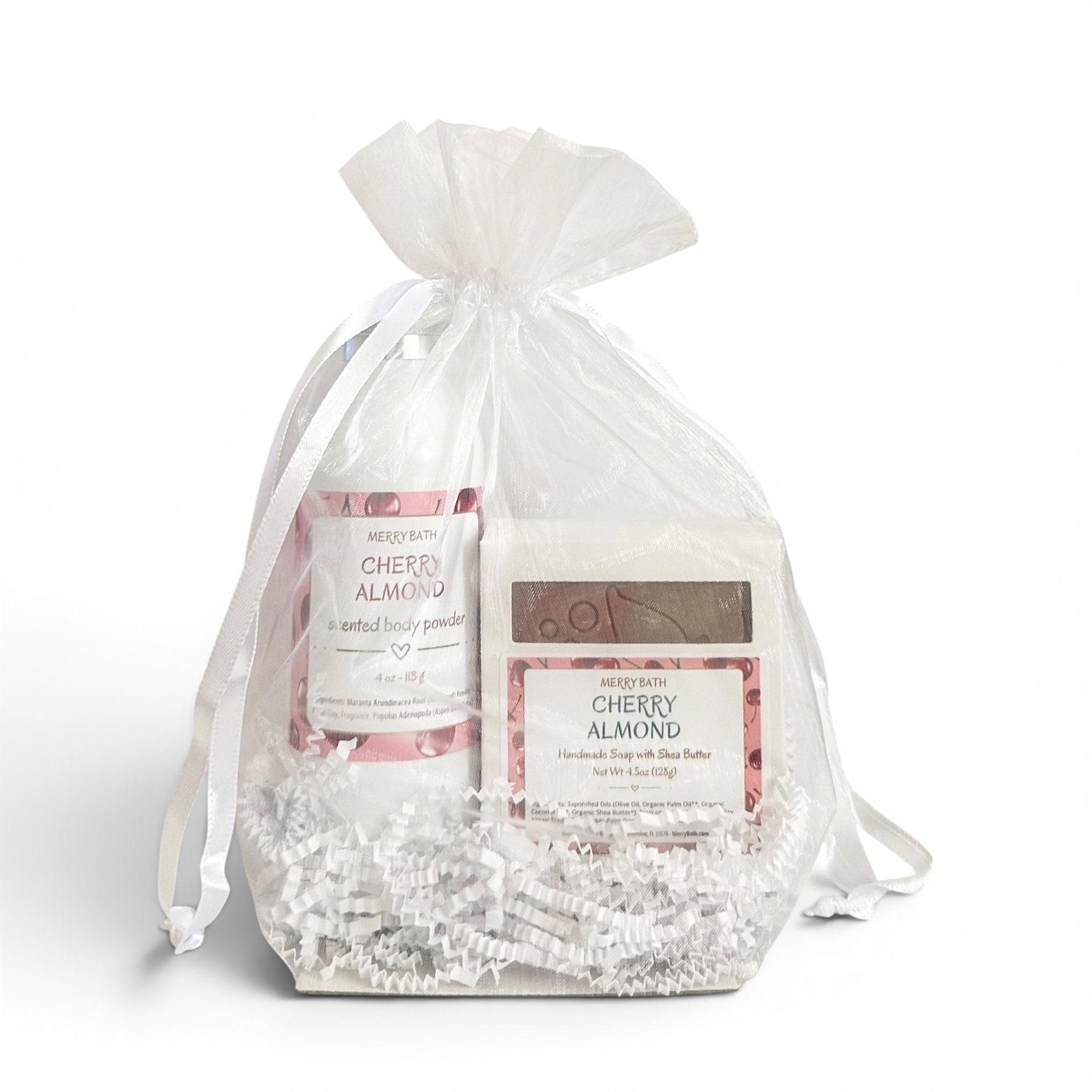 Gift set with cherry almond body products in a clear drawstring bag on a white background