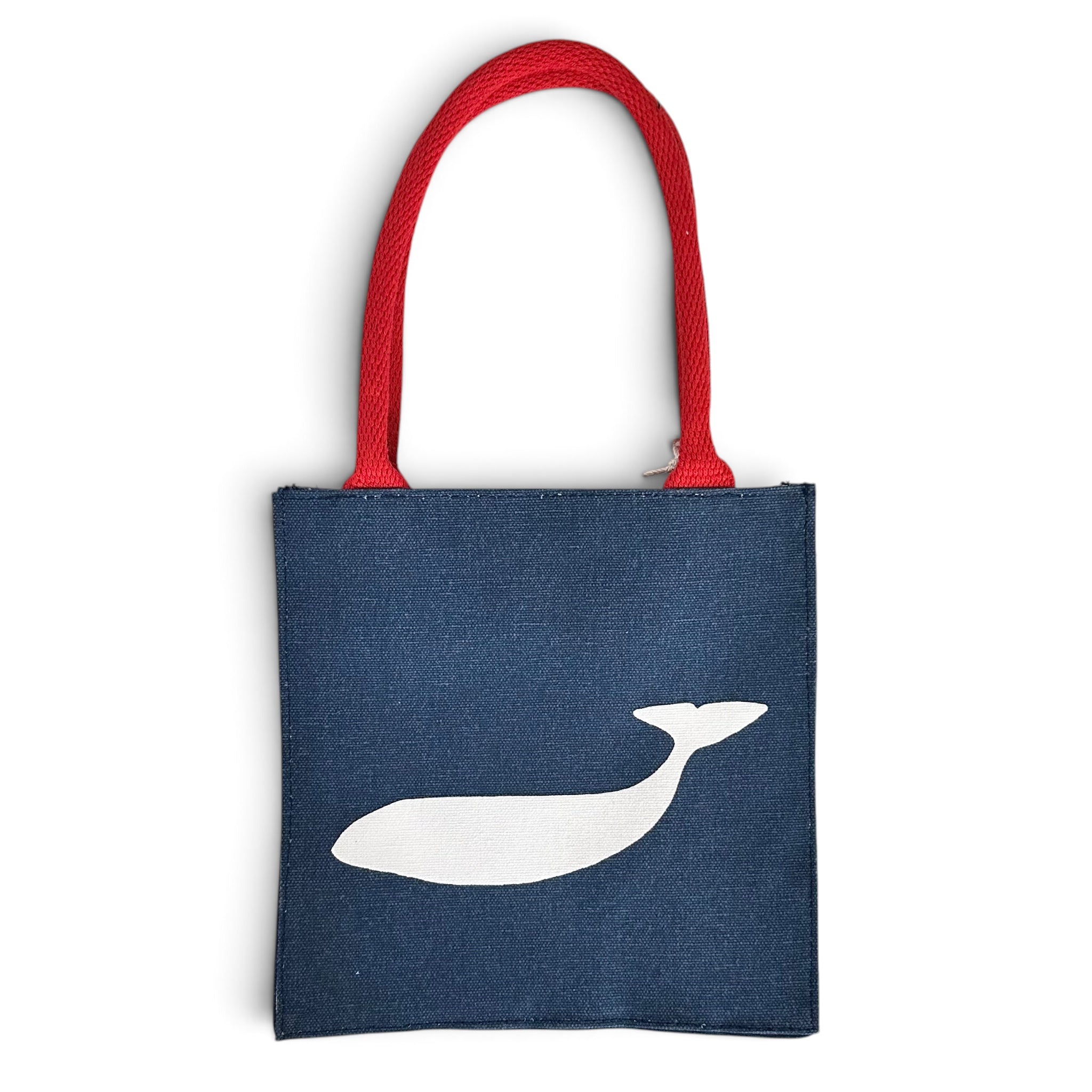 A navy blue canvas tote bag with a white whale silhouette printed on the front and bright red woven shoulder straps, shown against a plain white background.