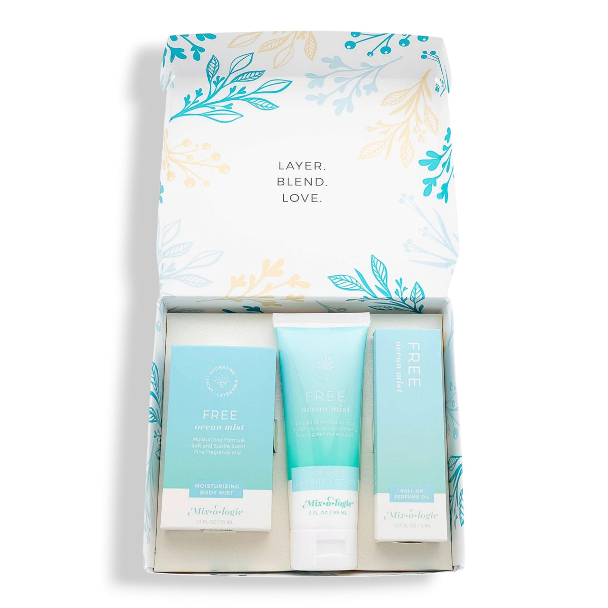 A skincare gift set by Mishebiologie, featuring a white box with teal and gold botanical illustrations, containing a light blue serum mist, a light blue face toner, and a light blue face cream.
