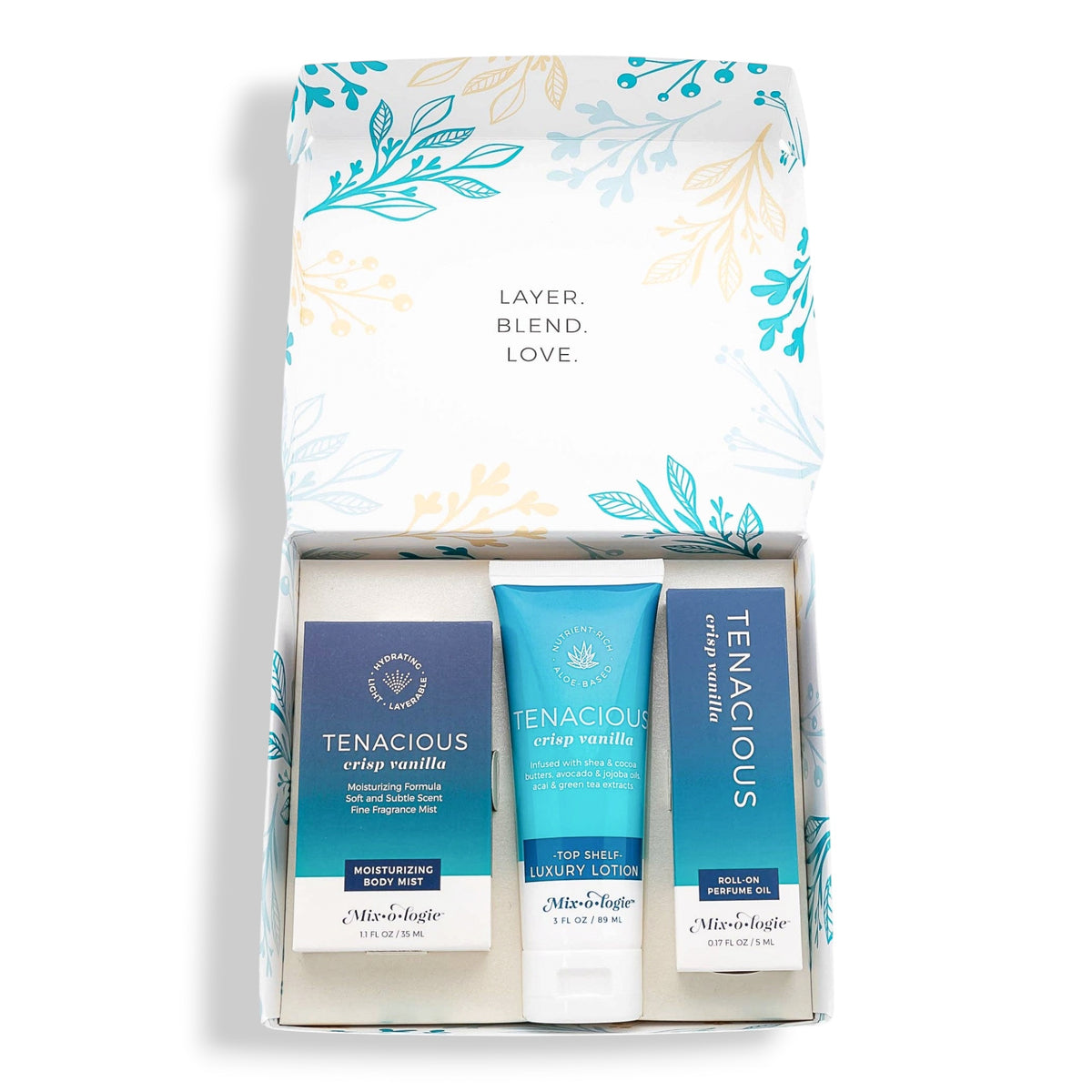 A 3-piece gift set from Mixologie featuring Tenacious Crisp Vanilla shampoo, leave-in conditioner, and hair oil, presented in a white box with blue and teal botanical illustrations.