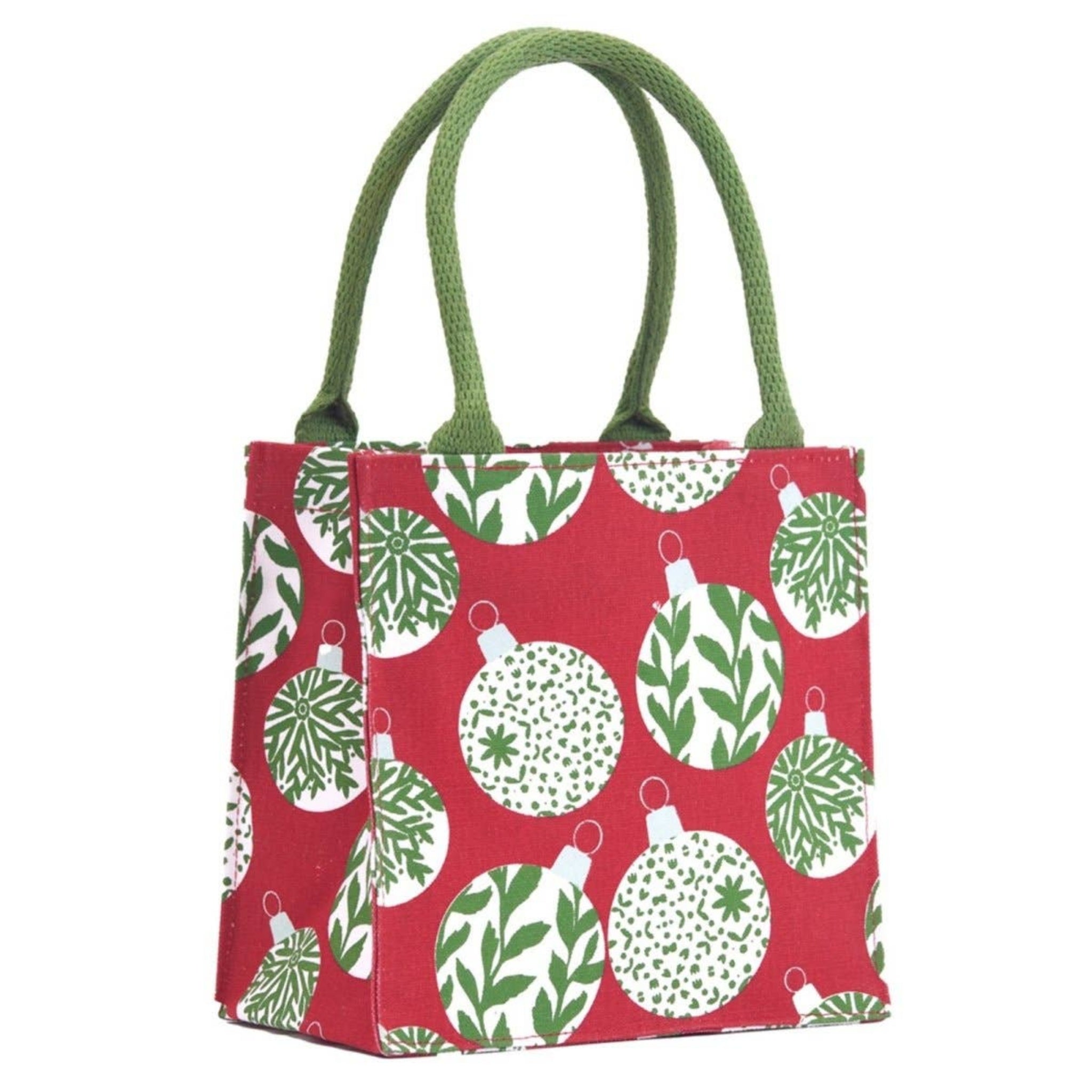 A small fabric tote bag with green rope handles, featuring a red background printed with white Christmas ornaments in green and white patterns.