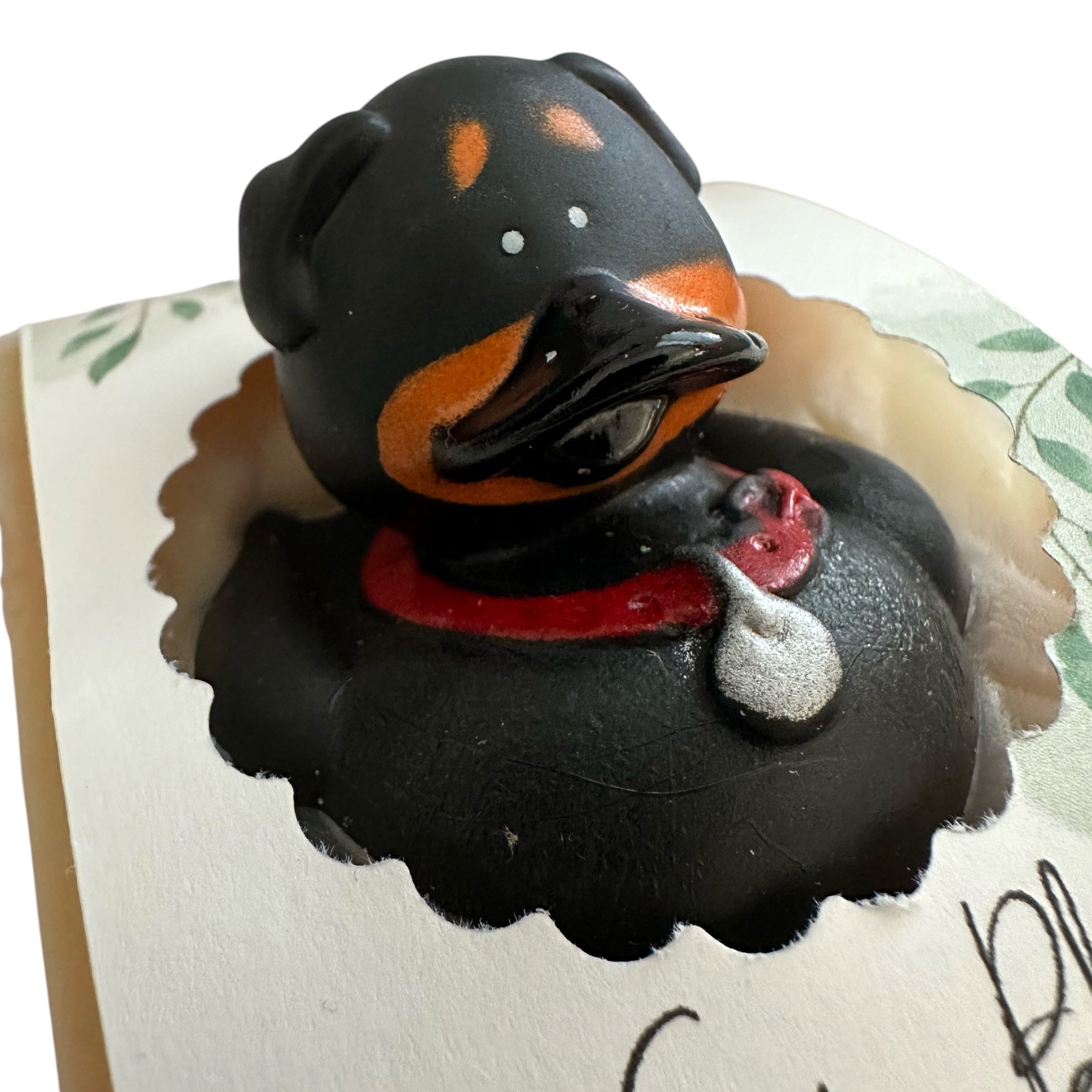 Handmade kids soap bar shaped like a black dog with orange spots and red collar