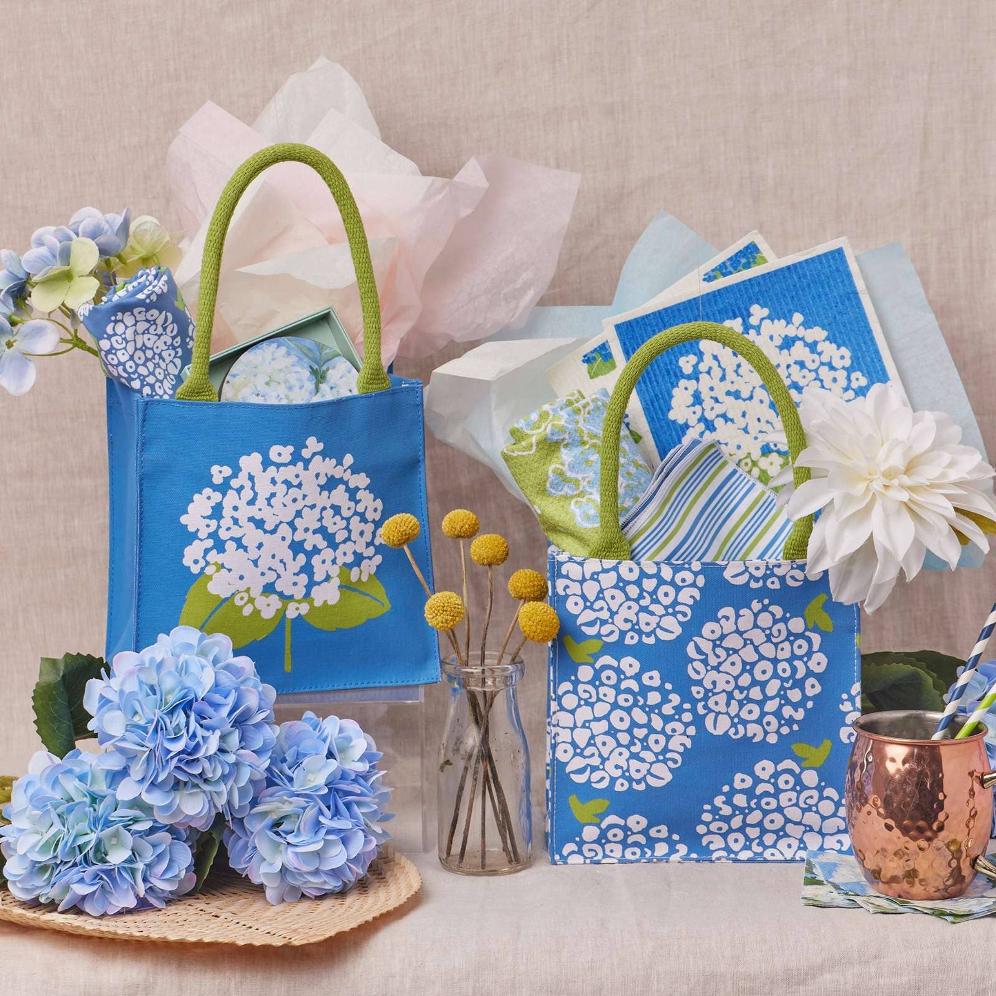Blue floral tote bag with flowers and cards on a neutral background