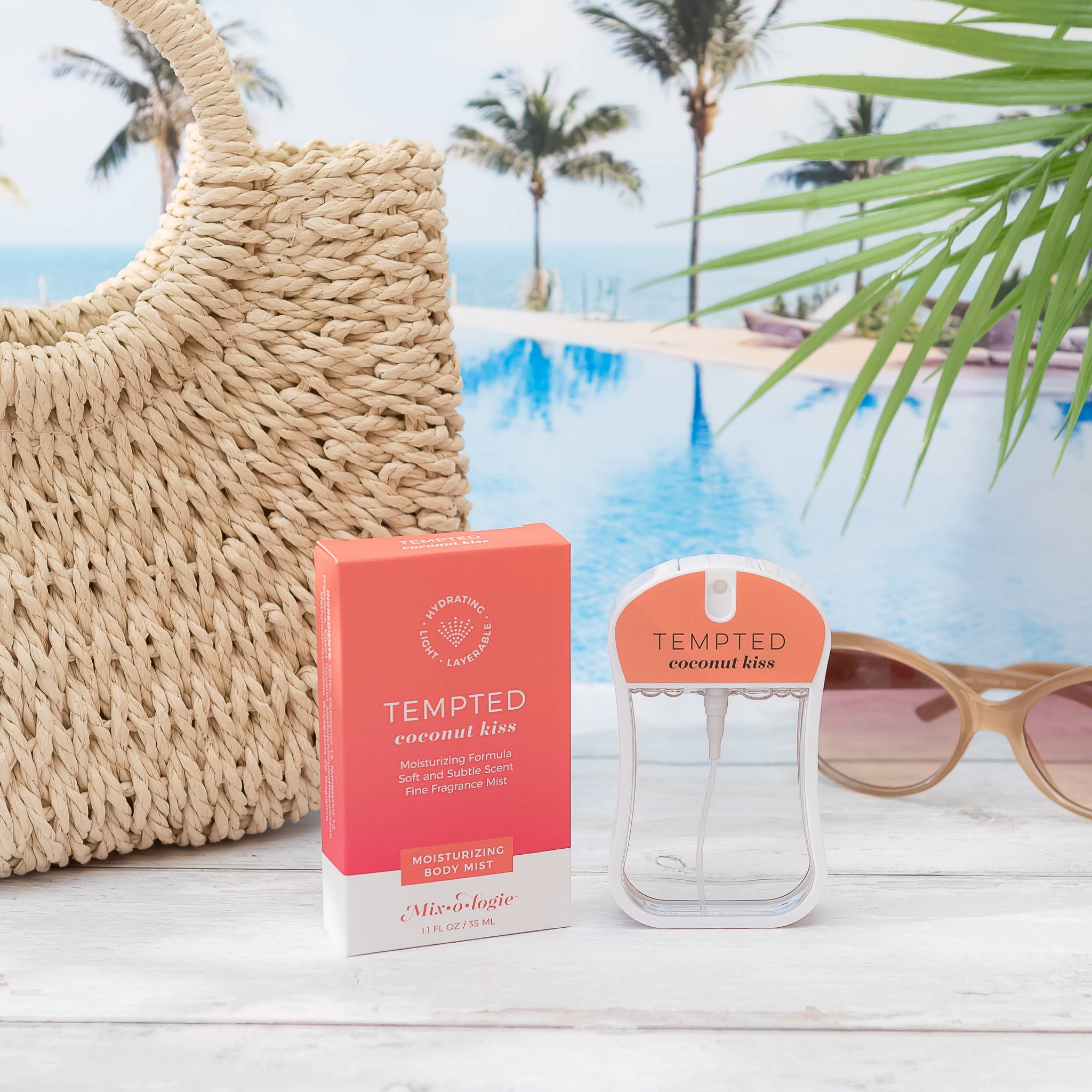 Tempted Coconut Kiss perfume bottle and packaging with a pool and palm trees in the background