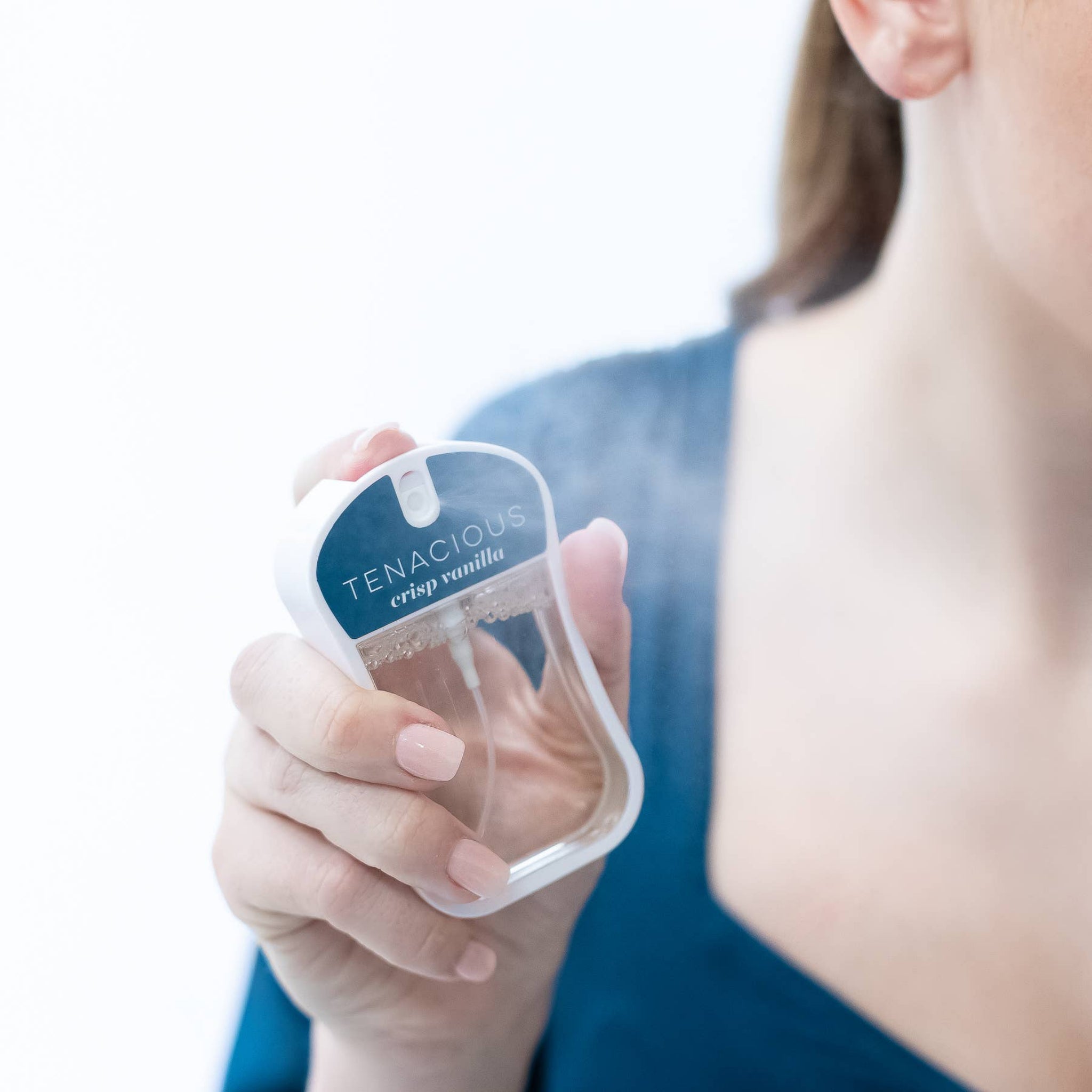 Hand holding a product labeled 'Tenacious' against a blurred background