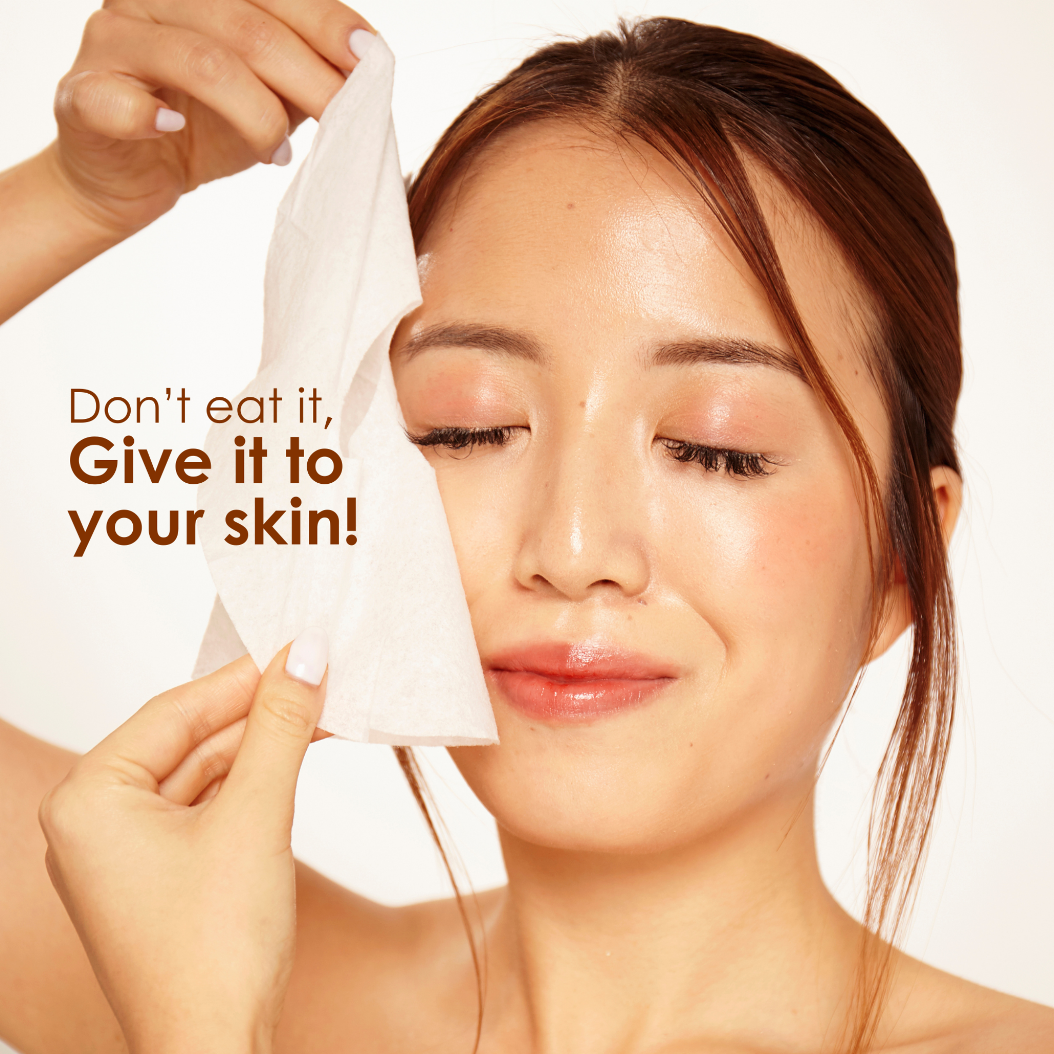 Person holding a white sheet mask against the face during self-care