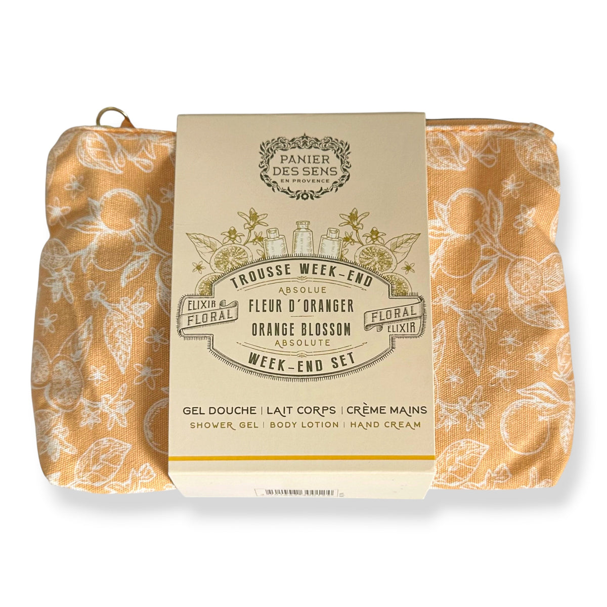 A packaged toiletry set from Panier des Sens featuring two peach-orange patterned towels wrapped around a cream paper sleeve labeled 'Trousse Week-End' with floral and botanical illustrations.