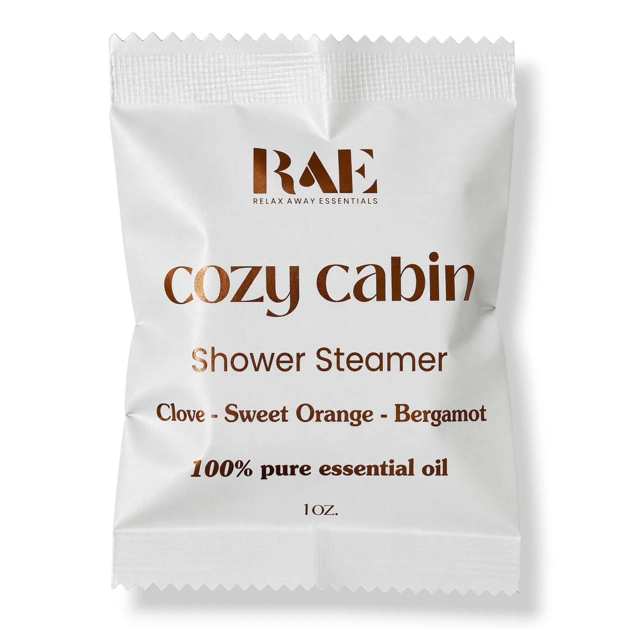 A single white sachet labeled RAE Cozy Cabin Shower Steamer, with brown text listing clove, sweet orange, and bergamot, on a white background.