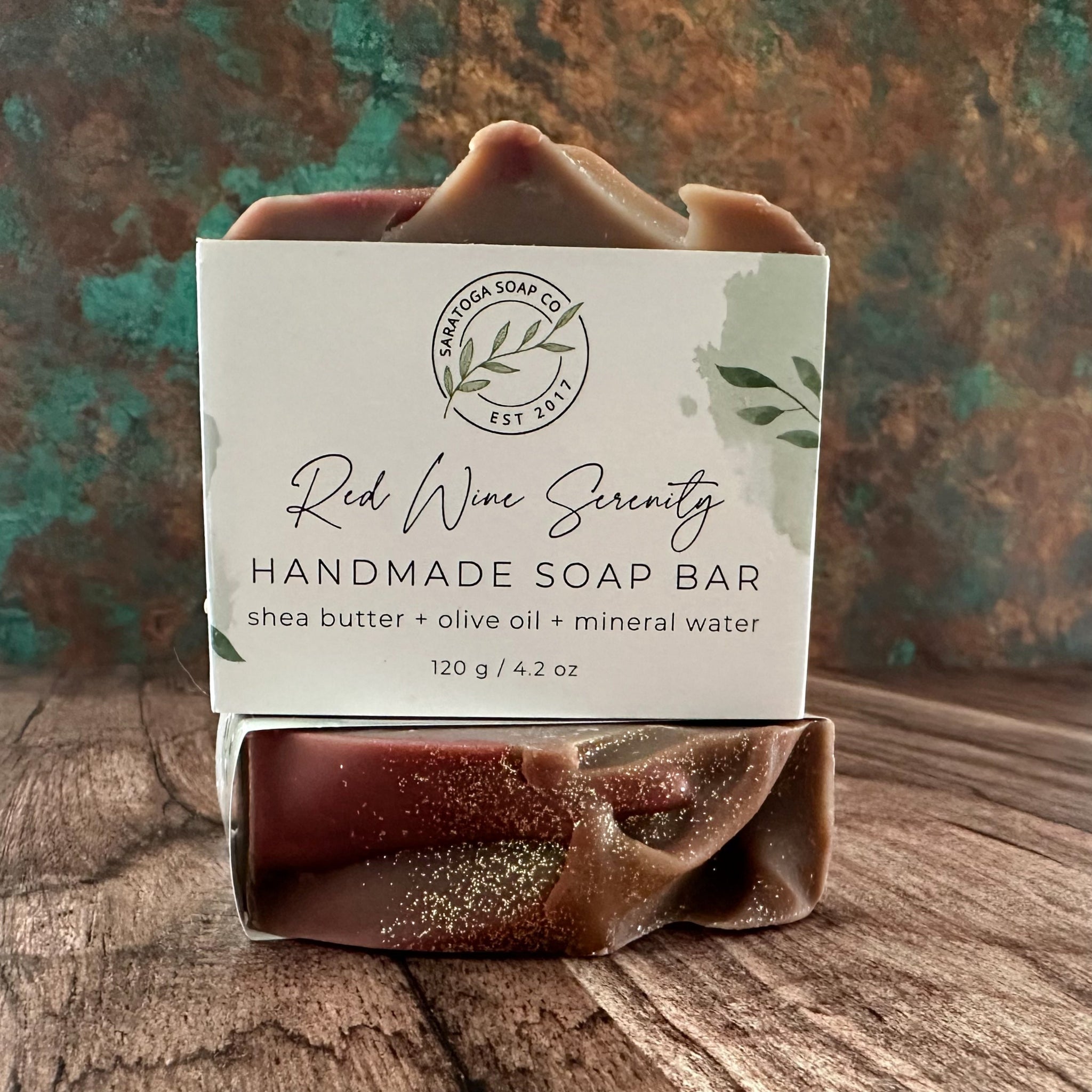 Handmade soap bar in dark red, presented in white logo box