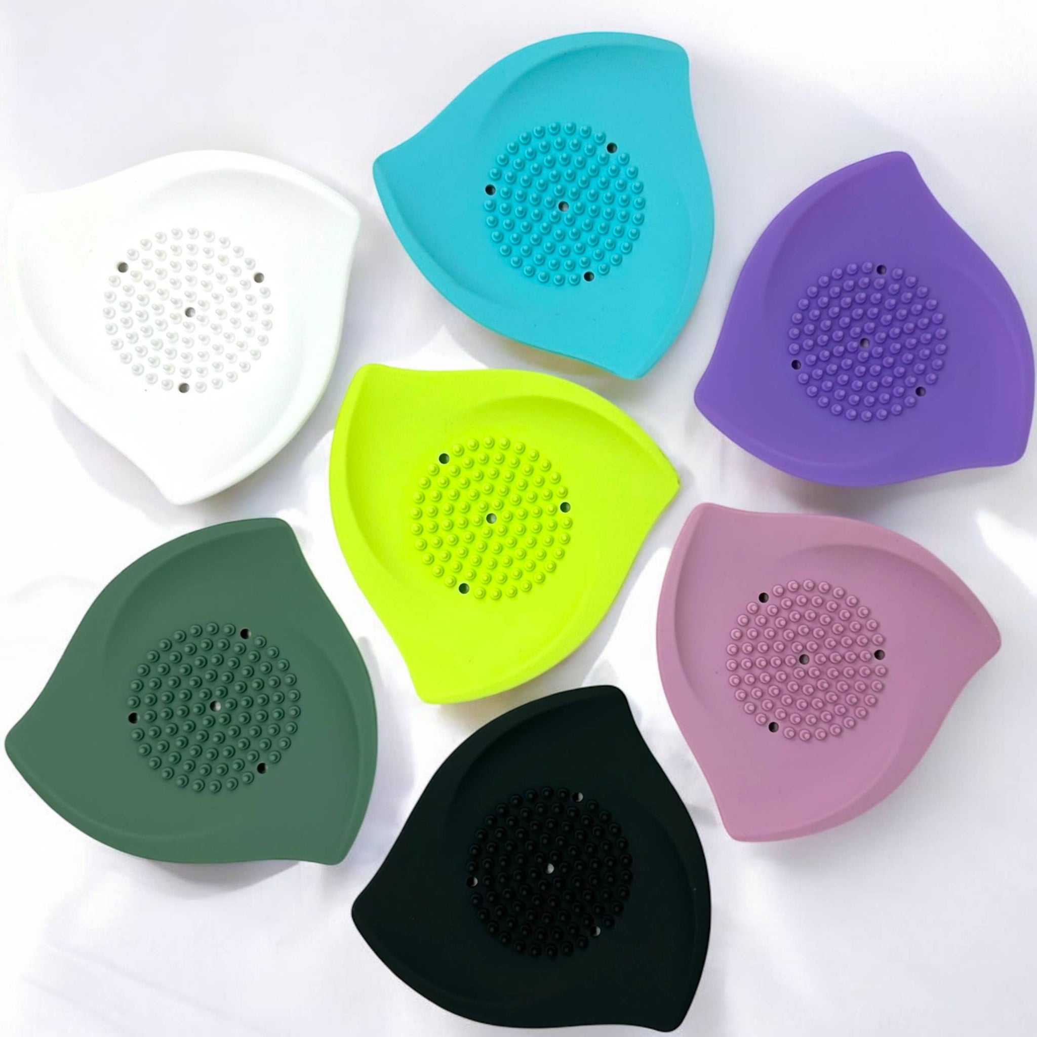 Assorted silicone shower steamer trays in white, teal, purple, pink, lime, green, and black
