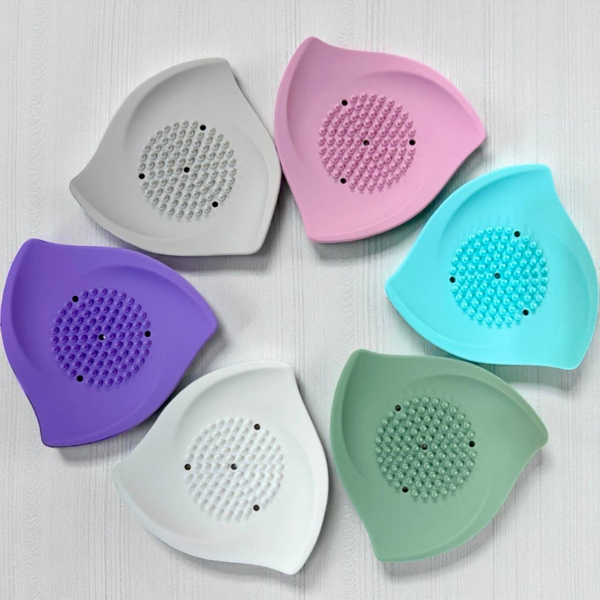 Silicone shower steamer trays in gray, pink, teal, purple, white, and sage green
