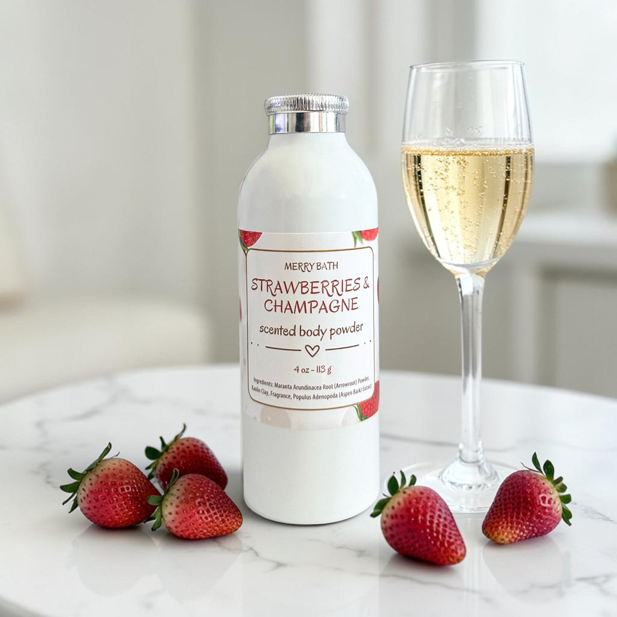 Scented body powder bottle with Strawberries & Champagne label, on countertop